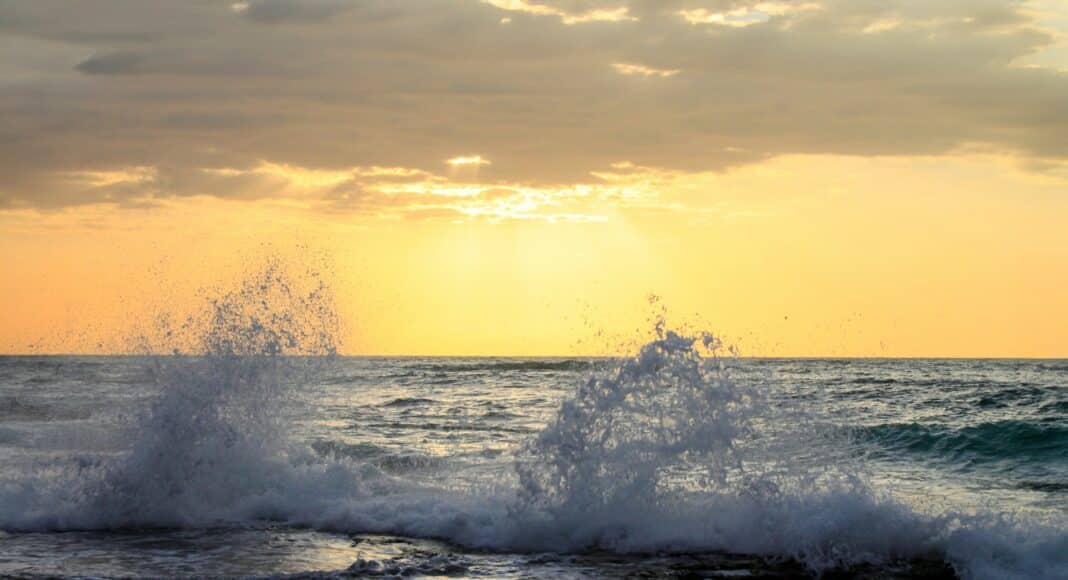 The sun is setting over the ocean waves