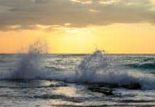 The sun is setting over the ocean waves