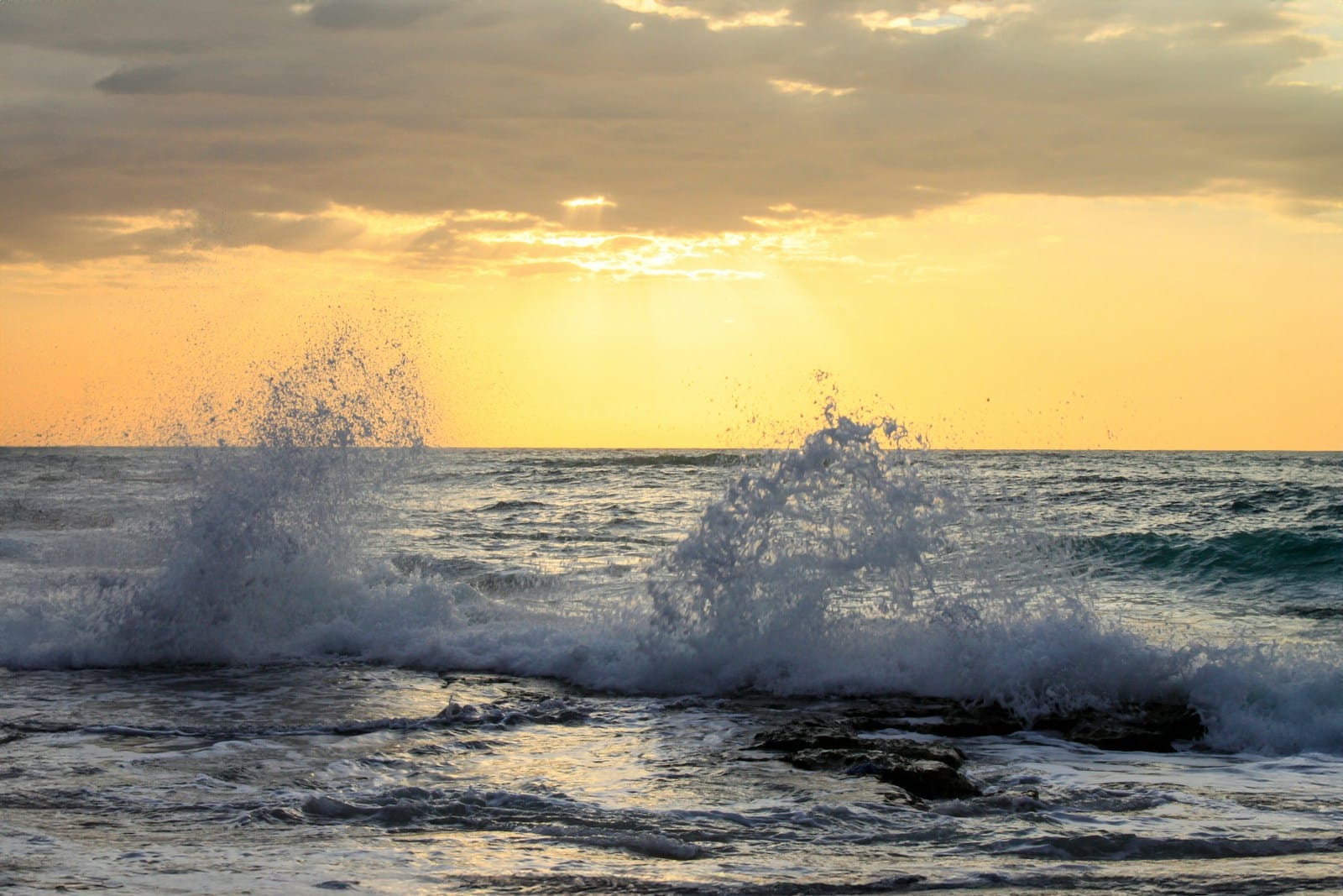 The sun is setting over the ocean waves