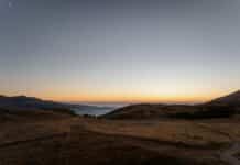 The sun is setting over a mountain range