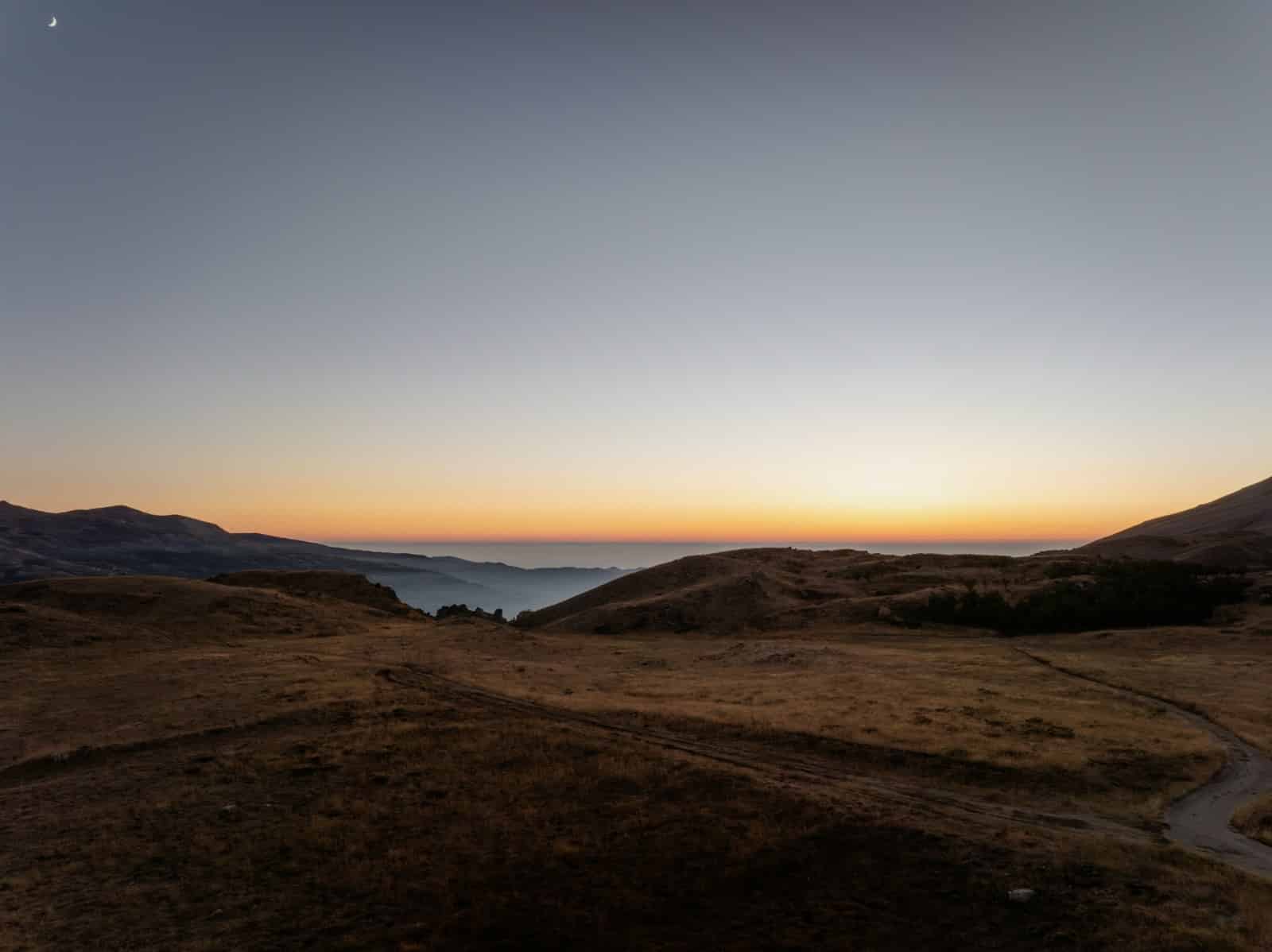 Revue de presse libanaise: Impact de la chute du régime syrien sur le Liban et la région The sun is setting over a mountain range