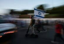 A blurry photo of a man riding a scooter