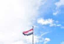 a flag flying in front of a sign that says atlanta