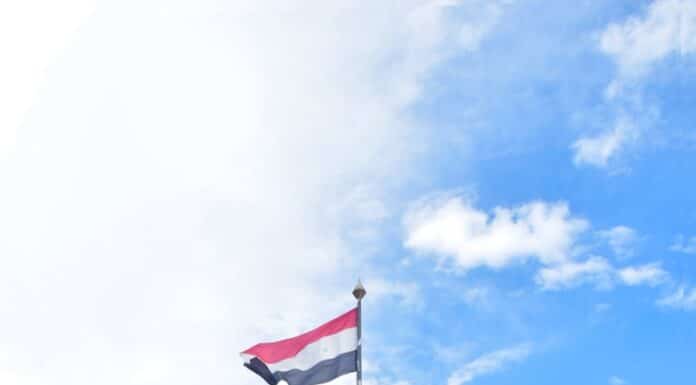 a flag flying in front of a sign that says atlanta