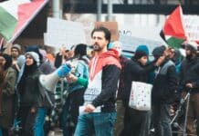 Revue de presse israélienne: Les négociations sur les otages en cours a man holding a megaphone in front of a crowd of people