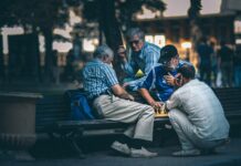 man in blue and white plaid dress shirt sitting on bench