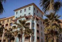 a tall blue building with palm trees in front of it