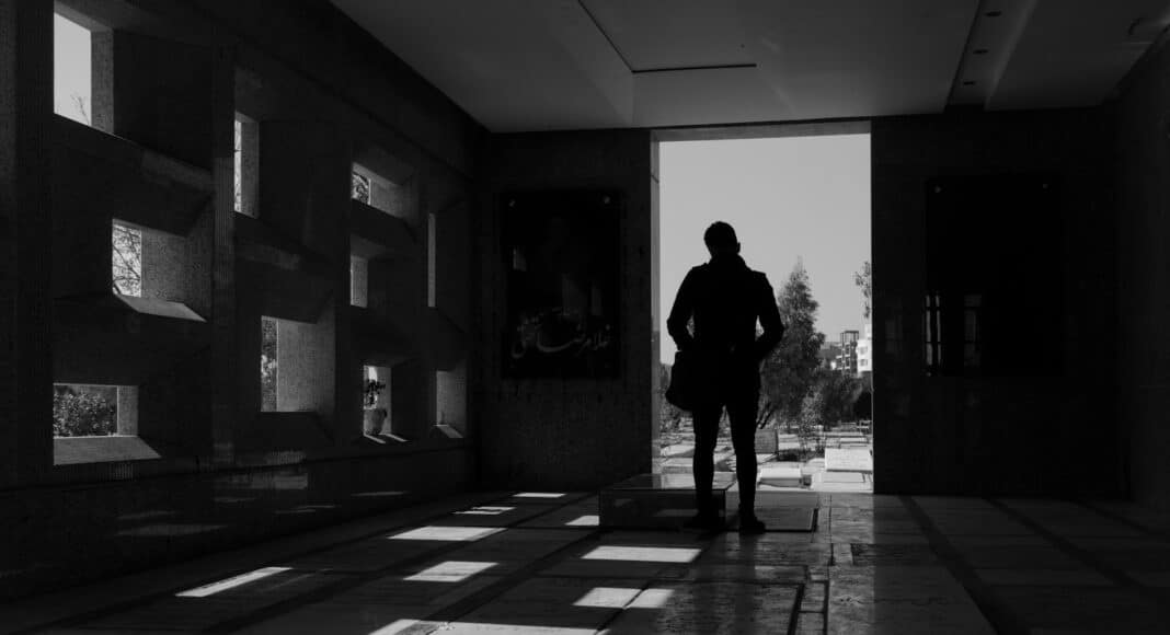 man in black jacket standing in the hallway