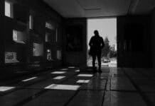 man in black jacket standing in the hallway