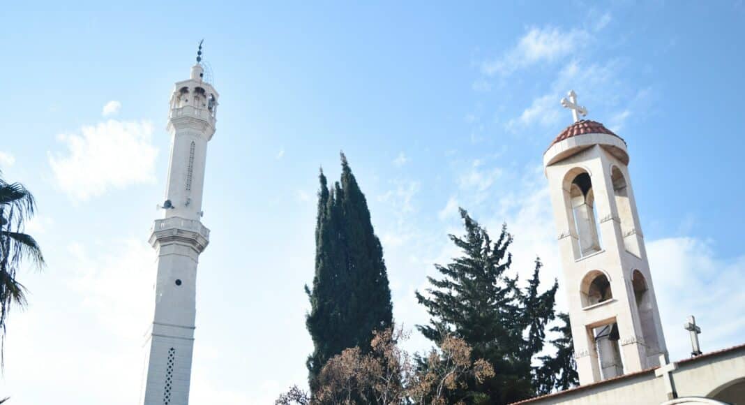a tall white clock tower sitting next to a tall white building