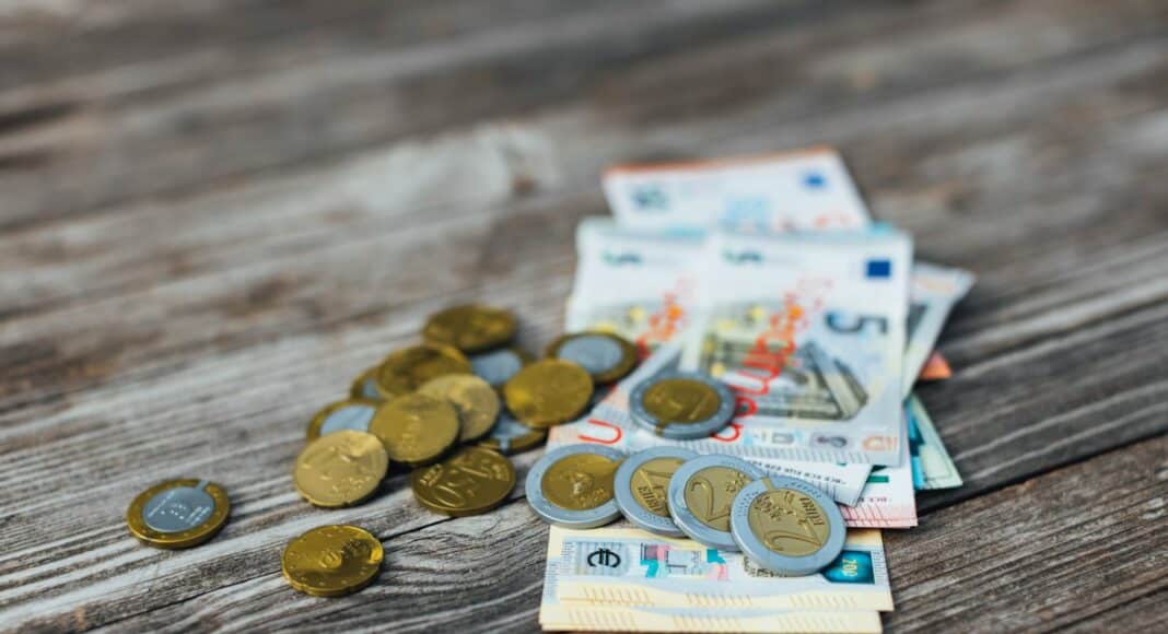 a pile of money sitting on top of a wooden table