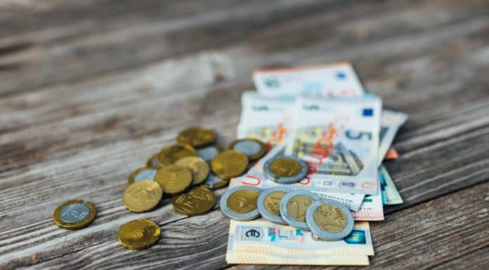a pile of money sitting on top of a wooden table
