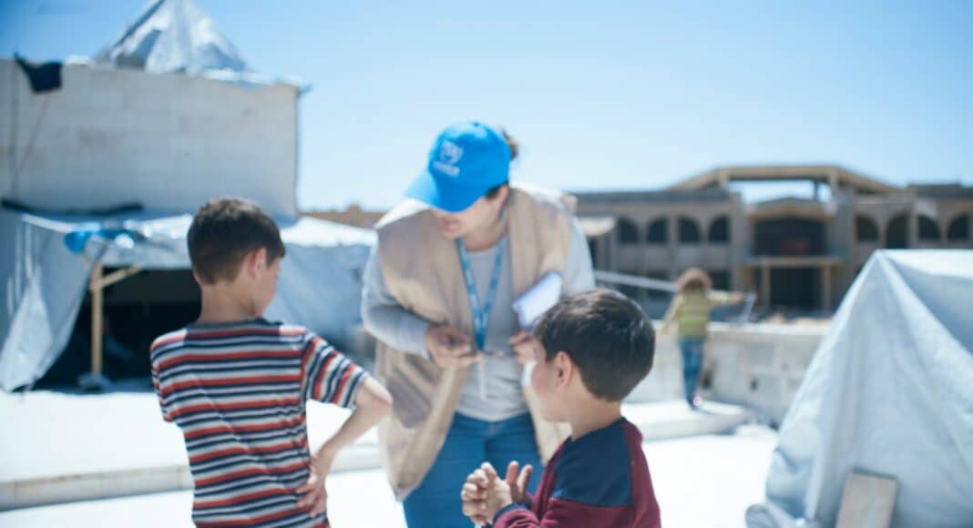 a woman standing next to two small boys