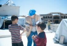 a woman standing next to two small boys