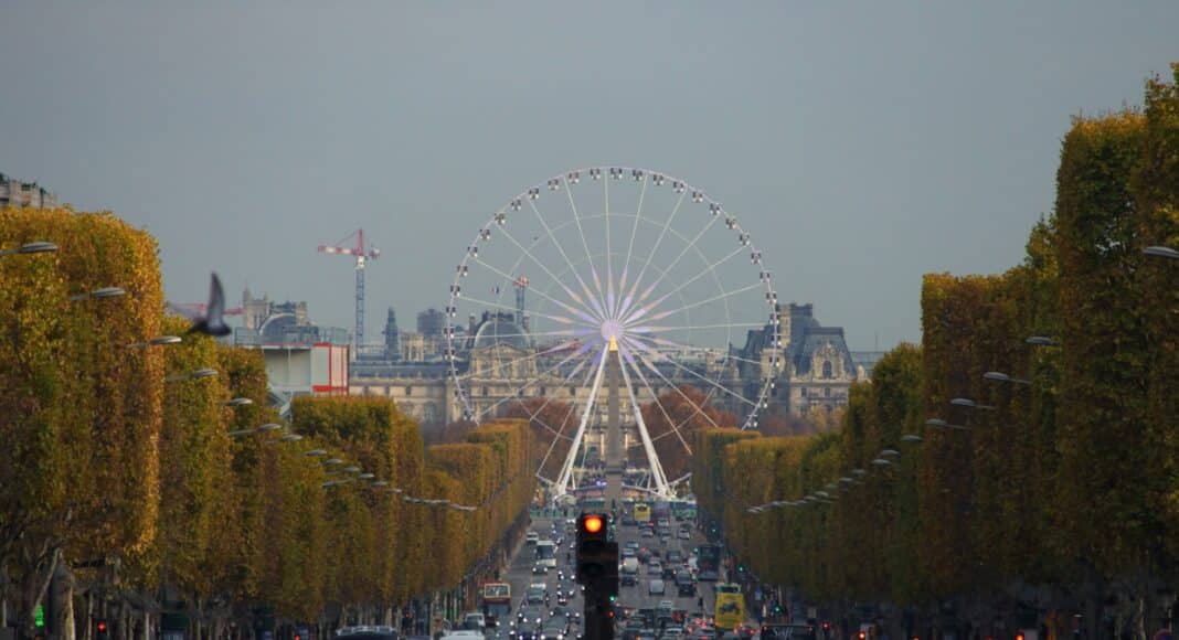 white ferris wheel in the middle of concrete road at daytime