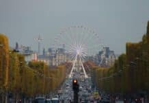 white ferris wheel in the middle of concrete road at daytime