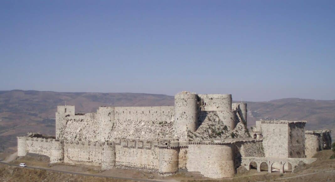 gray concrete castle on green grass field under blue sky during daytime