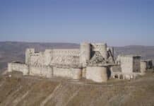 gray concrete castle on green grass field under blue sky during daytime