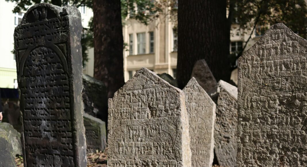 A cemetery with headstones and trees in the background