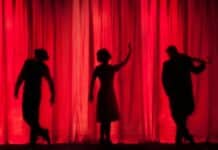 silhouette of three performers on stage