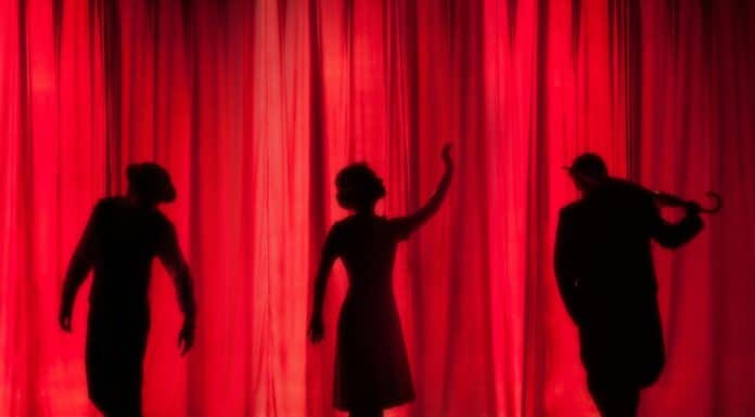 silhouette of three performers on stage