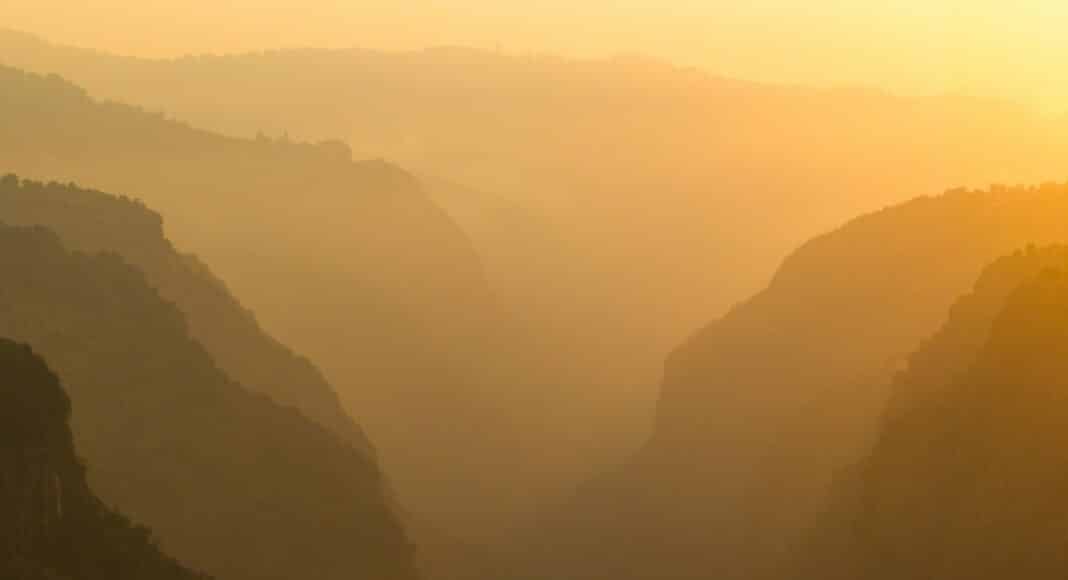 A view of a valley with mountains in the background