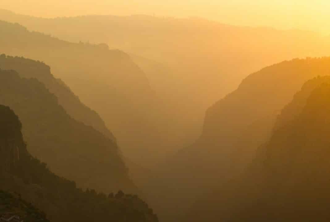 A view of a valley with mountains in the background