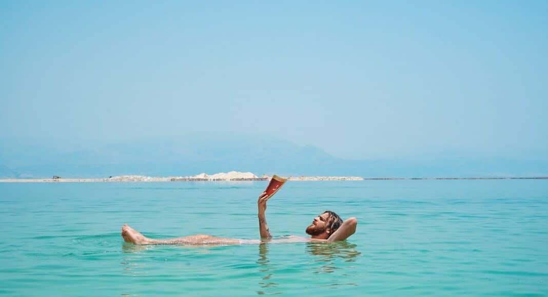 person on body of water reading book