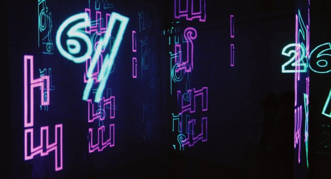 neon signs are lit up in a dark room