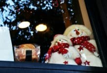 white snowman plush toy on glass window
