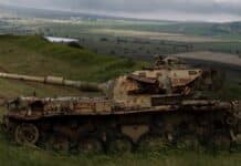 a military tank driving through a field