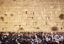 Entre ultraorthodoxes et la société israélienne, rien ne va plus a crowd of people standing in front of a stone wall