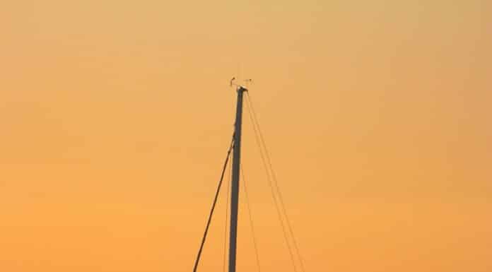 a sailboat in the ocean at sunset