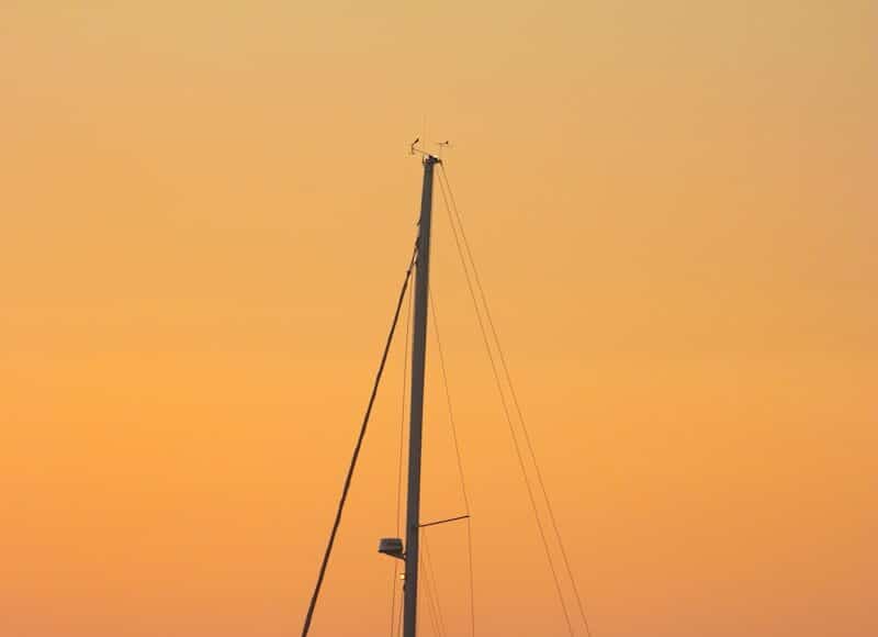 a sailboat in the ocean at sunset