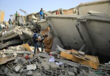 a group of people standing next to a collapsed building