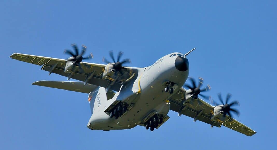 grey military cargo plane on flight under clear blue sky