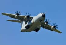 grey military cargo plane on flight under clear blue sky