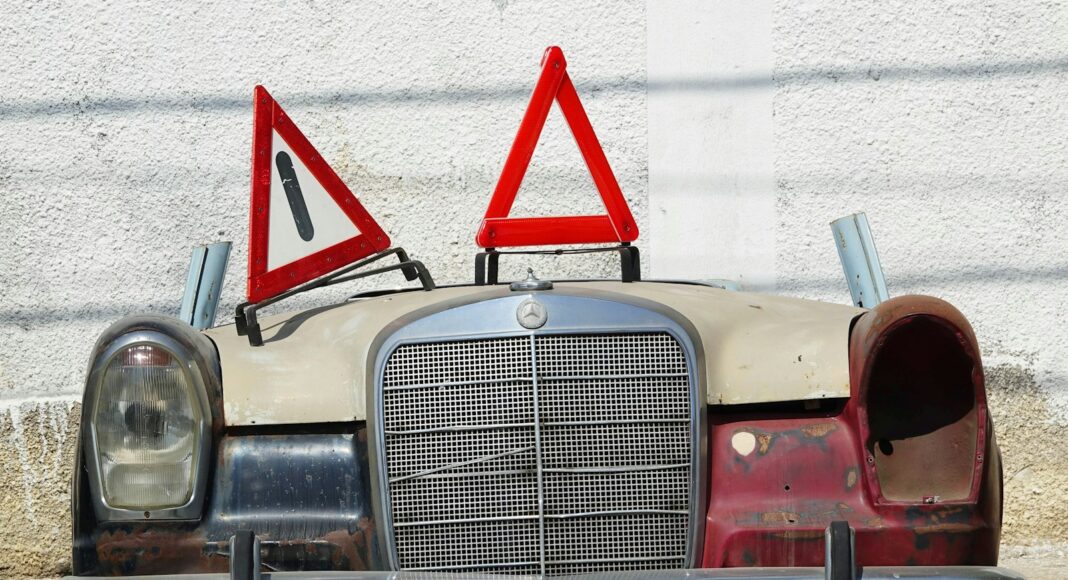 an old car with a warning sign on top of it