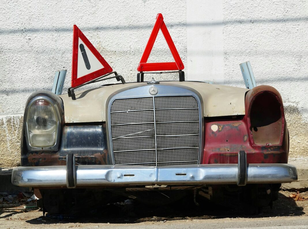 an old car with a warning sign on top of it