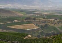 a scenic view of a valley with a winding road