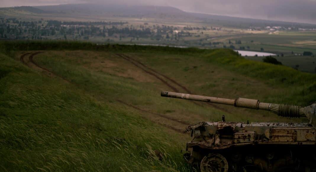 a military tank driving through a field