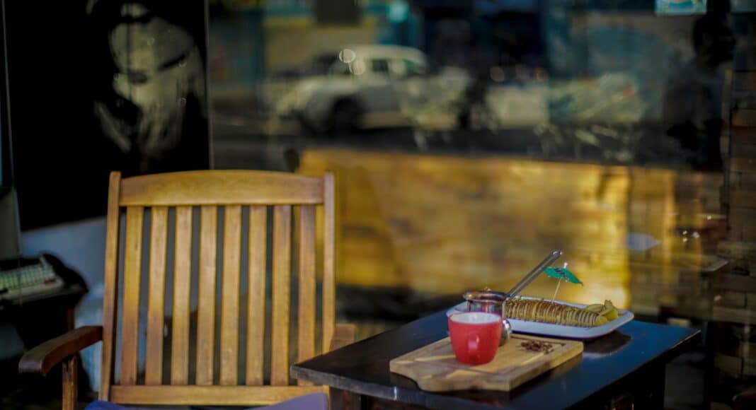a table with a chair and a window with a view of a street