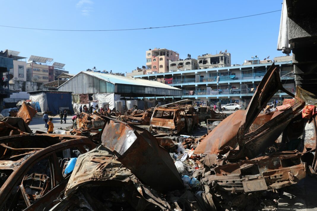 A man standing next to a pile of junk