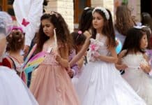 2 women in white dress holding hands