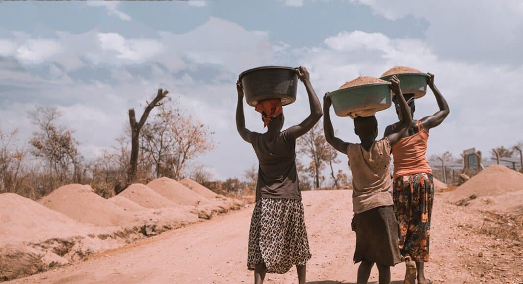 three women carrying basin while walking barefoot