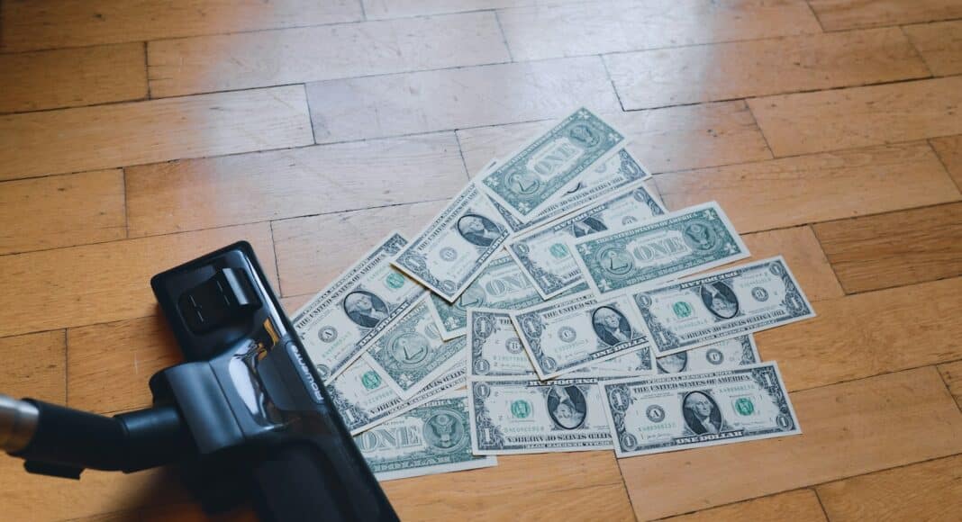 a pile of money sitting on top of a wooden floor