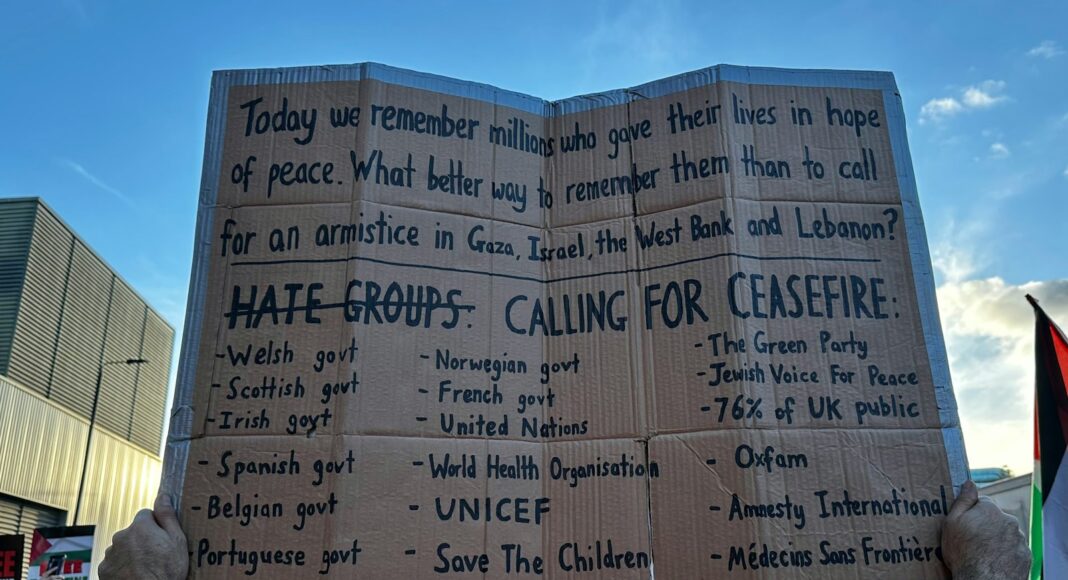 a person holding a cardboard sign in front of a crowd