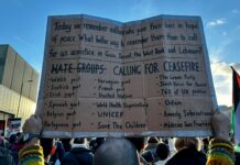 a person holding a cardboard sign in front of a crowd