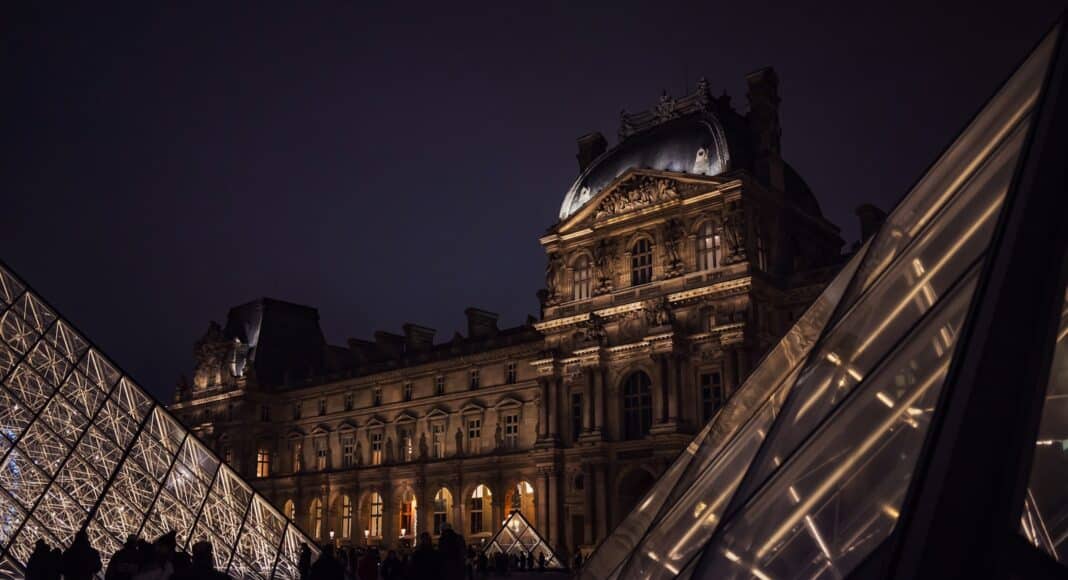 A very tall building with a very tall pyramid in front of it