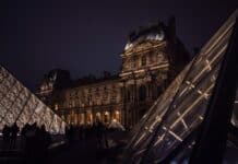 A very tall building with a very tall pyramid in front of it